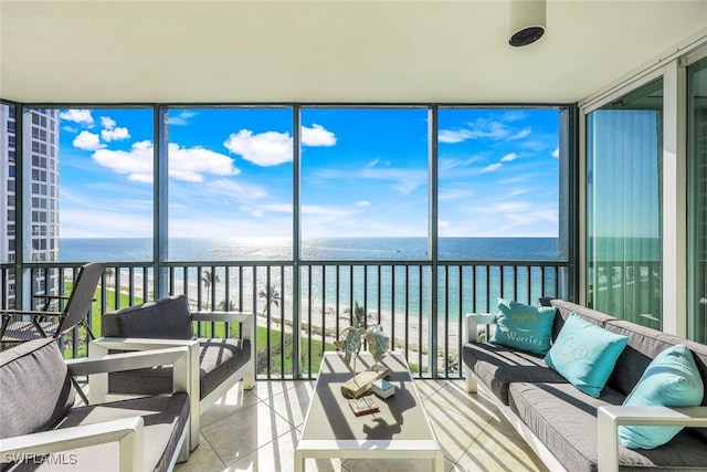 sunroom / solarium featuring a water view and a beach view