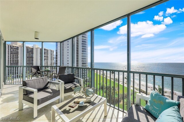 sunroom with a view of the beach and a water view