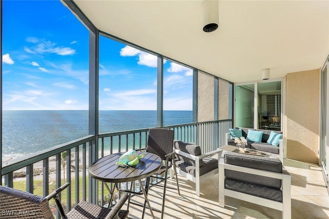 sunroom / solarium featuring a water view