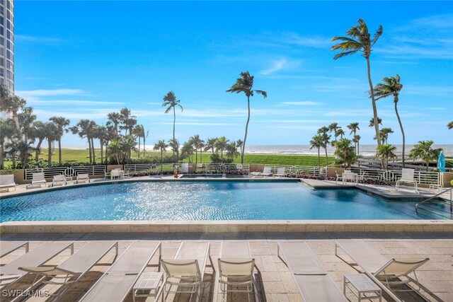 view of swimming pool with a water view and a patio