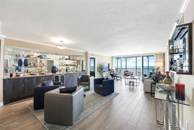 living room featuring hardwood / wood-style floors, expansive windows, crown molding, and a textured ceiling