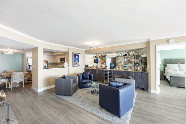 living room featuring bar area, ornamental molding, and hardwood / wood-style flooring