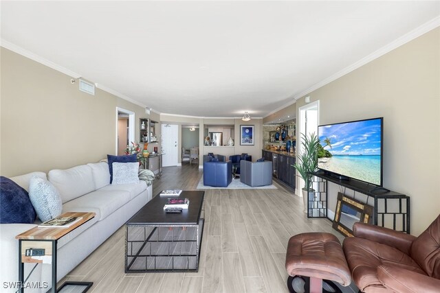 living room with light wood-type flooring and ornamental molding