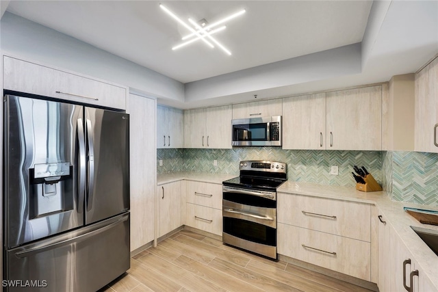 kitchen featuring decorative backsplash, light hardwood / wood-style flooring, stainless steel appliances, and light brown cabinets