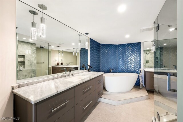 bathroom with plus walk in shower, tile patterned flooring, vanity, and tile walls