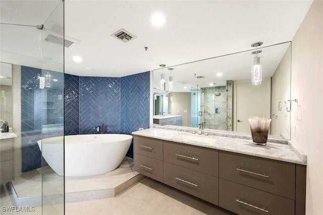 bathroom with tile patterned floors, vanity, shower with separate bathtub, and tile walls