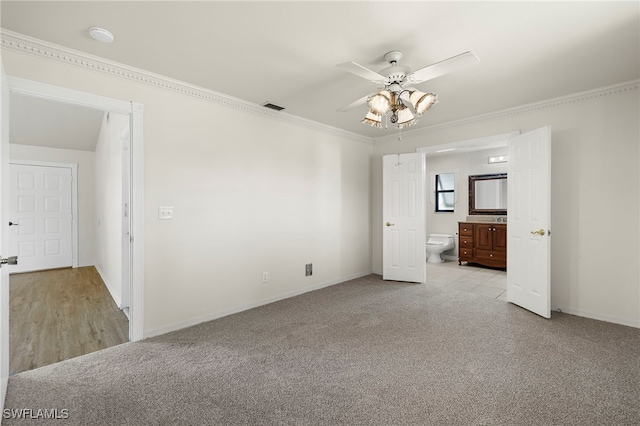 unfurnished bedroom with ceiling fan, crown molding, ensuite bathroom, and light colored carpet