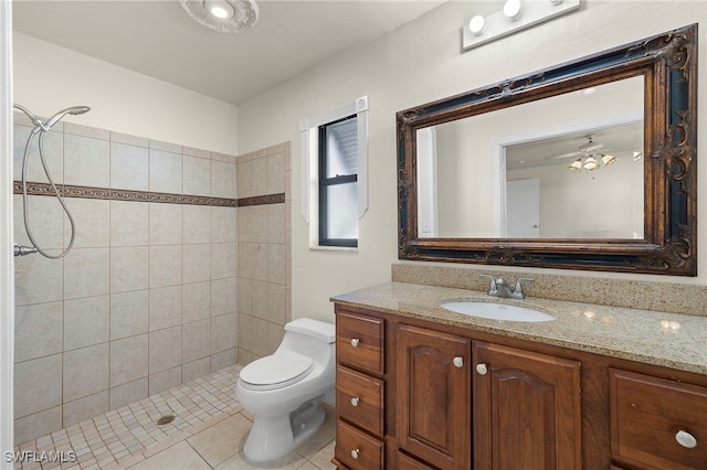 bathroom with vanity, tiled shower, toilet, and tile patterned floors