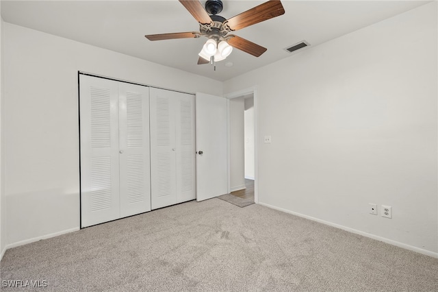 unfurnished bedroom with light colored carpet, a closet, and ceiling fan