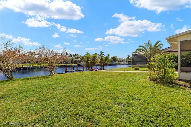 view of yard with a water view and glass enclosure