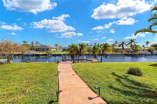 dock area with a lawn and a water view