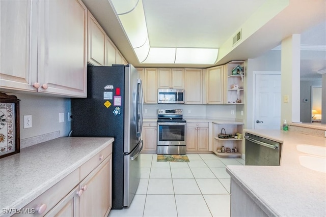 kitchen featuring light brown cabinets, light tile patterned flooring, ornamental molding, and stainless steel appliances