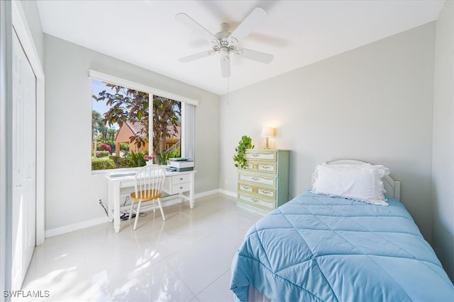 tiled bedroom with a closet, built in desk, and ceiling fan