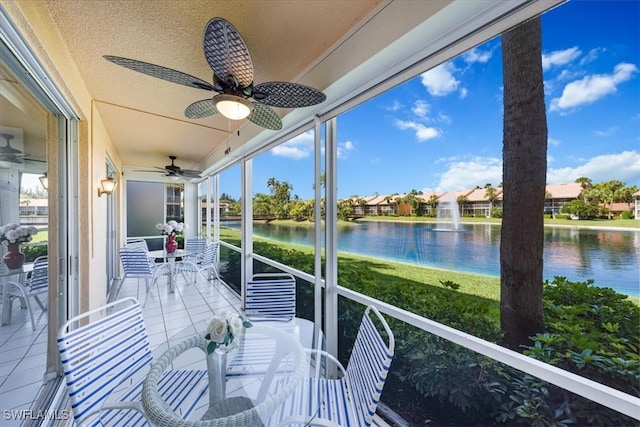 unfurnished sunroom featuring a water view and ceiling fan