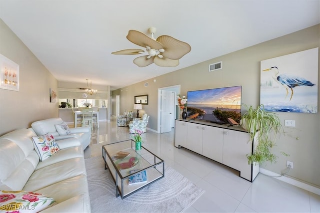 tiled living room with ceiling fan with notable chandelier