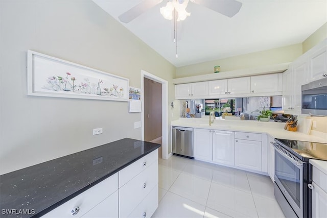 kitchen featuring white cabinetry, stainless steel appliances, decorative backsplash, and light tile patterned flooring