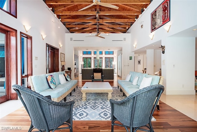 living room featuring wooden ceiling, beam ceiling, high vaulted ceiling, and hardwood / wood-style floors