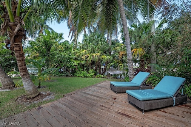 wooden terrace featuring a lawn