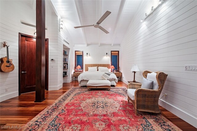 bedroom with ceiling fan, wood-type flooring, wooden walls, and vaulted ceiling with beams