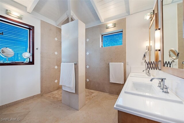 bathroom with tiled shower, vaulted ceiling with beams, vanity, wood ceiling, and tile patterned flooring