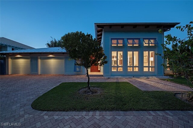 view of front of home featuring a garage and a yard