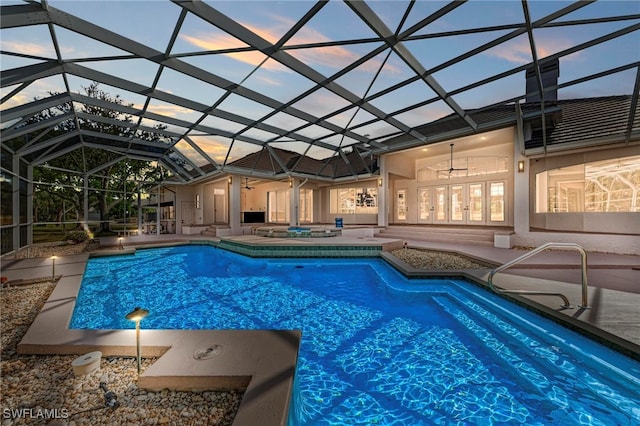 pool at dusk featuring a patio, ceiling fan, and glass enclosure