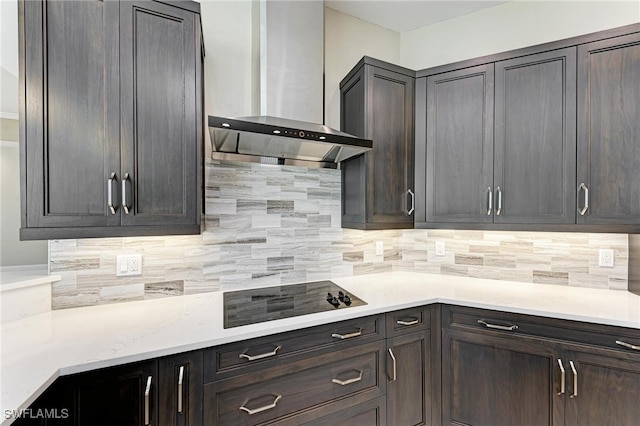 kitchen featuring black electric stovetop, dark brown cabinets, wall chimney range hood, and decorative backsplash