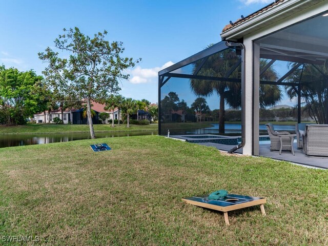 view of yard with a patio, a water view, and glass enclosure