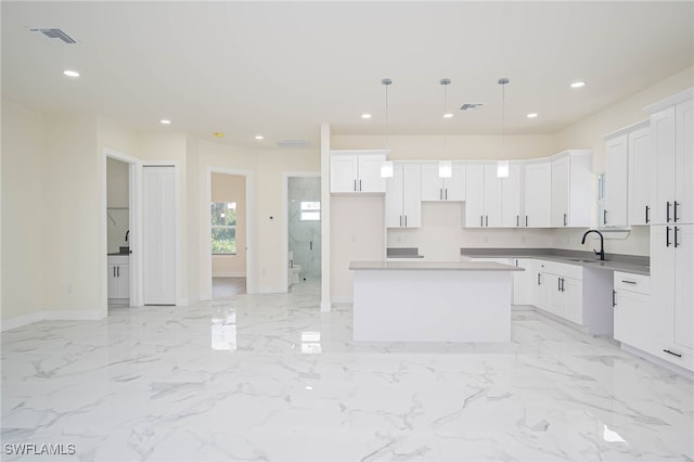 1949 Mariano St, Lehigh Acres, FL 33972 - kitchen with a kitchen island, baseboards, a sink, recessed lighting, and white cabinetry