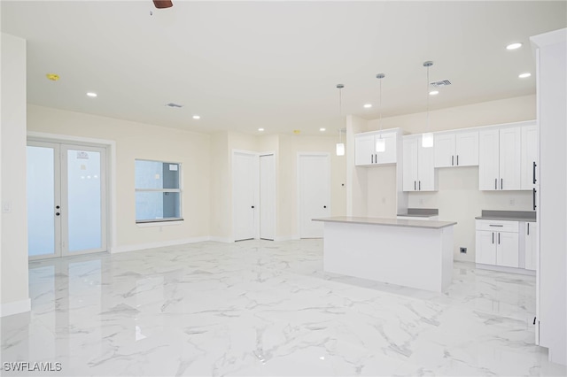 kitchen with a kitchen island, white cabinetry, decorative light fixtures, and ceiling fan