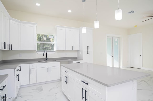 1949 Mariano St, Lehigh Acres, FL 33972 - kitchen with a sink, light marble finish flooring, recessed lighting, hanging light fixtures, and white cabinets