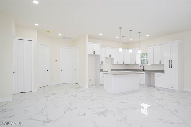 1949 Mariano St, Lehigh Acres, FL 33972 - kitchen with a kitchen island, baseboards, a sink, white cabinets, and recessed lighting