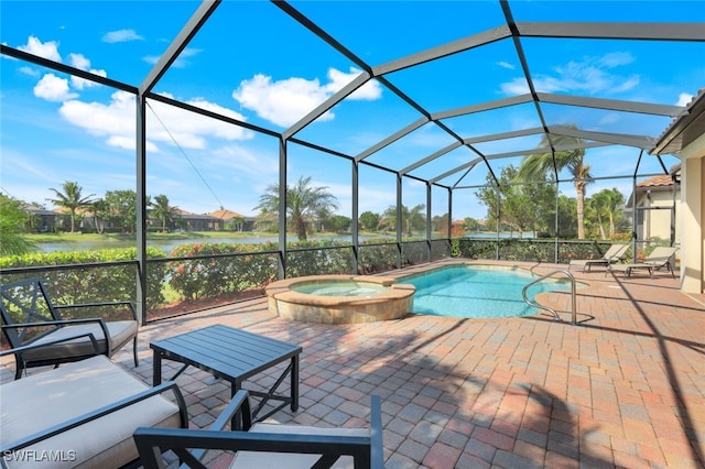 view of pool with an in ground hot tub, a patio, glass enclosure, and a water view