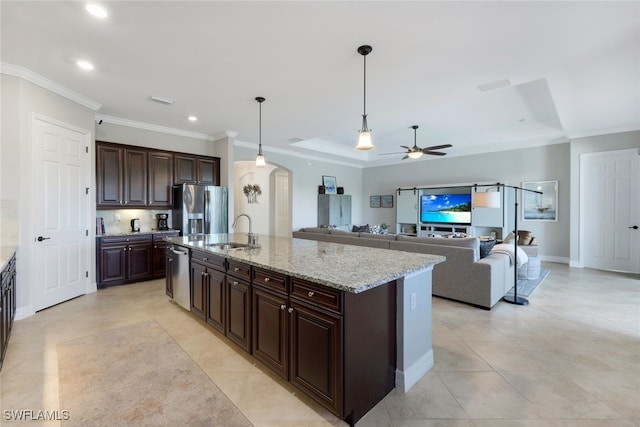 kitchen with dark brown cabinets, hanging light fixtures, ceiling fan, stainless steel appliances, and a kitchen island with sink