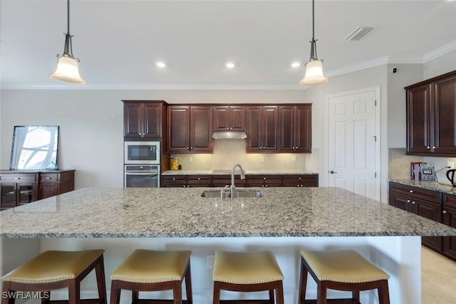 kitchen featuring a large island, backsplash, appliances with stainless steel finishes, and sink