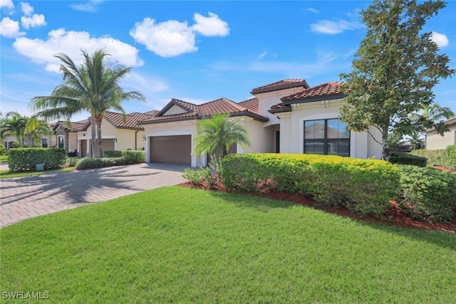 mediterranean / spanish-style home featuring a front yard and a garage