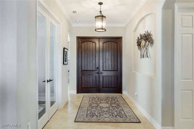 foyer with ornamental molding and light tile patterned floors