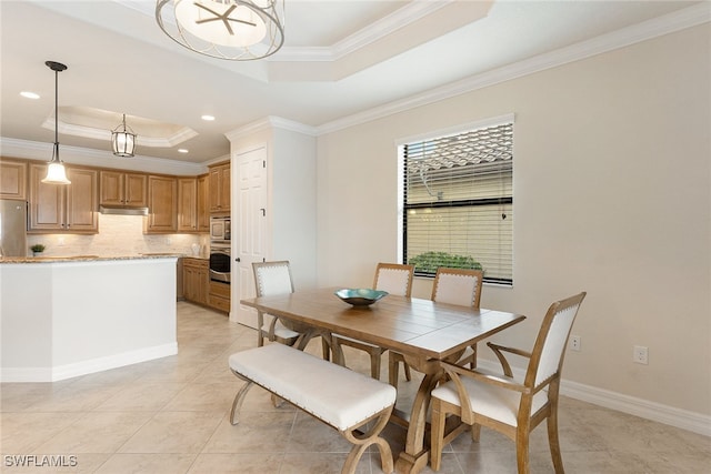 tiled dining room featuring ornamental molding and a raised ceiling