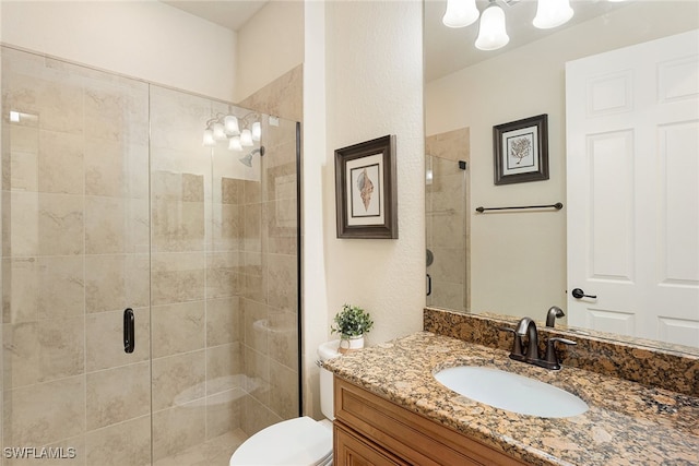 bathroom featuring vanity, toilet, and a shower with door