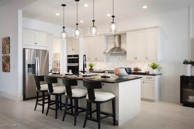 kitchen with tasteful backsplash, dark countertops, double oven, stainless steel fridge with ice dispenser, and wall chimney range hood