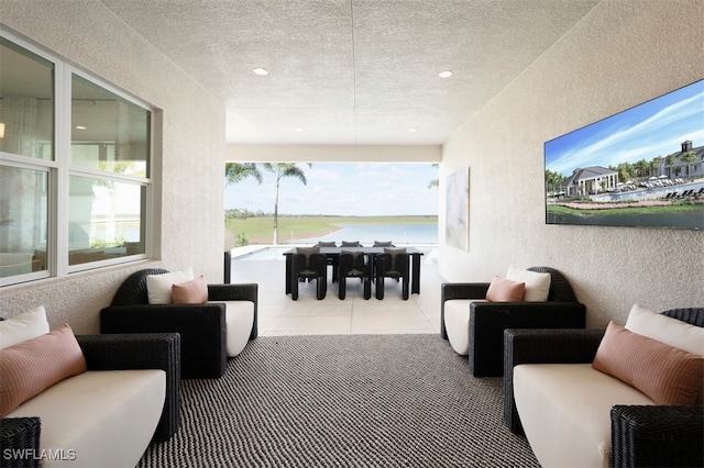 tiled living room with recessed lighting, a textured wall, and a textured ceiling