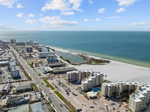 birds eye view of property with a water view and a beach view