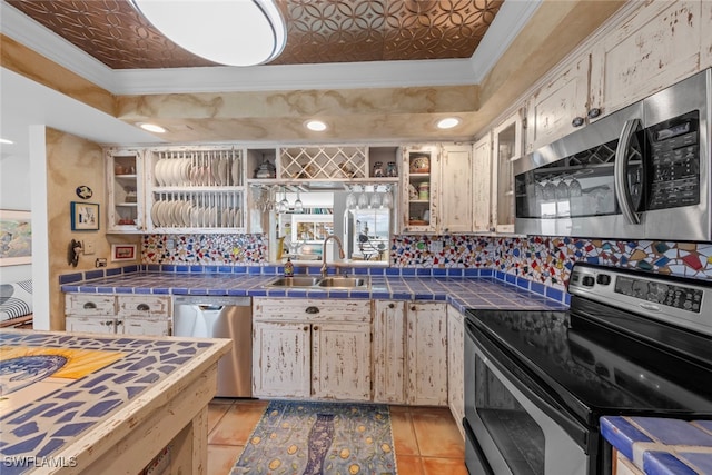 kitchen featuring sink, decorative backsplash, stainless steel appliances, and tile counters