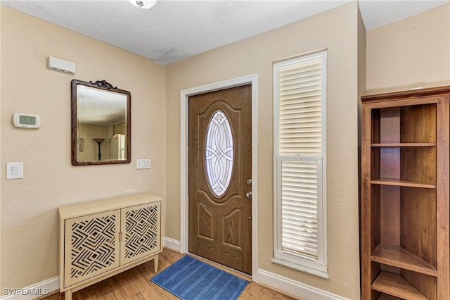 foyer with wood-type flooring and a textured ceiling