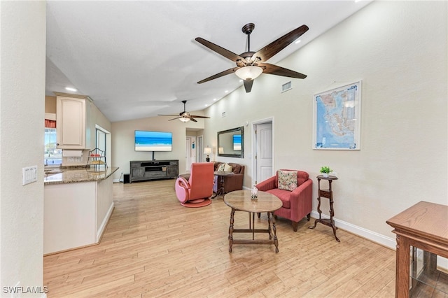 living room with light hardwood / wood-style flooring, lofted ceiling, and ceiling fan