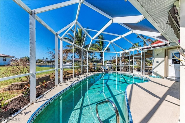 view of pool with a patio area, a water view, and glass enclosure