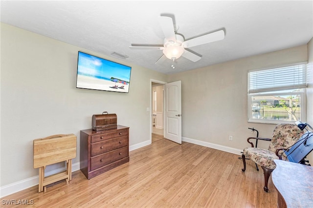 sitting room with light wood-type flooring and ceiling fan