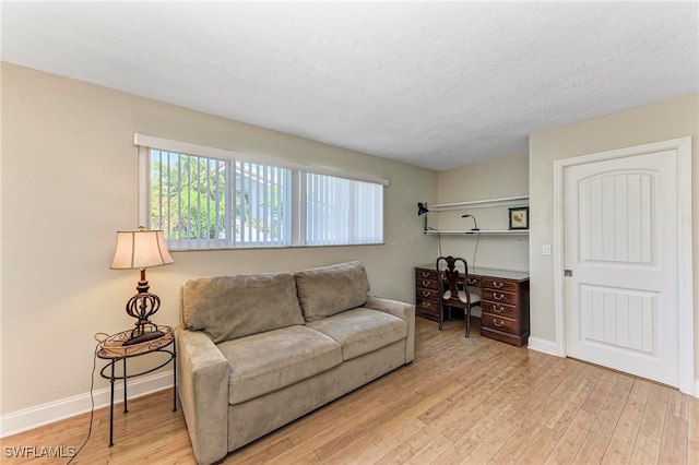 living room featuring light hardwood / wood-style floors and a textured ceiling