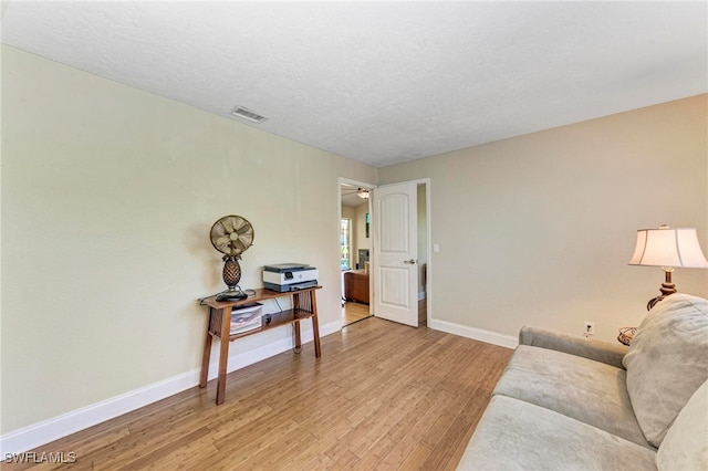 living room featuring light hardwood / wood-style floors and a textured ceiling