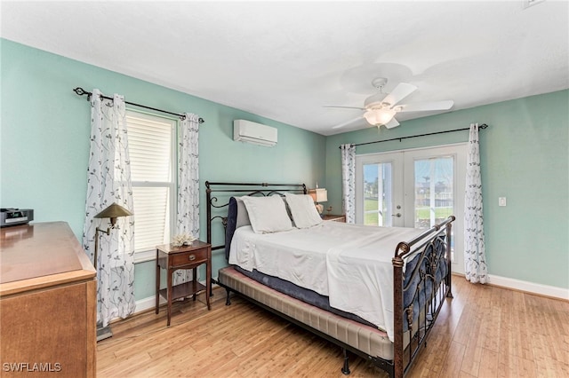 bedroom with ceiling fan, access to exterior, a wall mounted air conditioner, light hardwood / wood-style flooring, and french doors